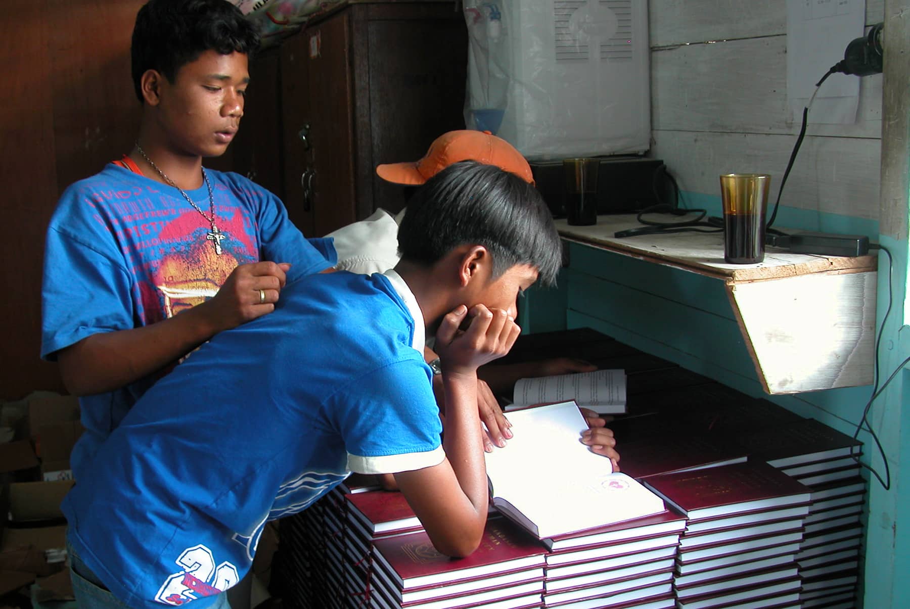 Indonesia Boys Leaning Against Piles Of Luther's Small Catechisms