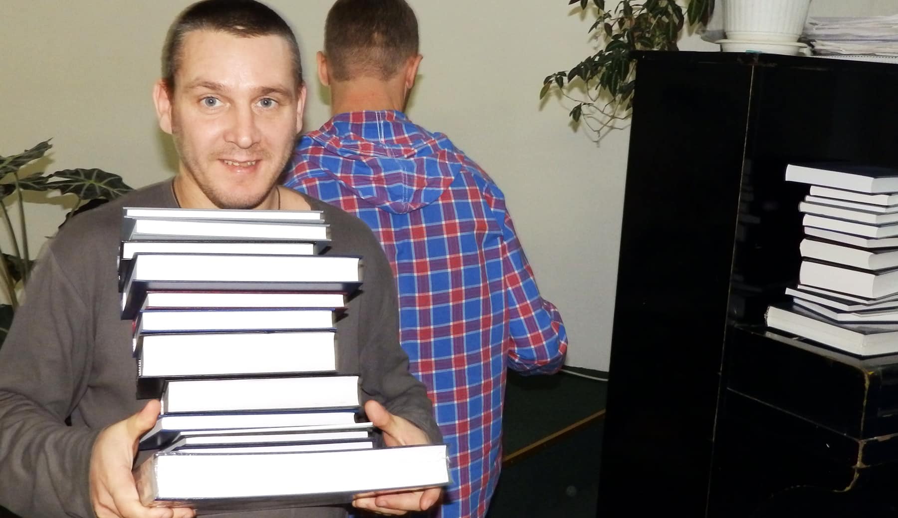 Russian man holding pile of books