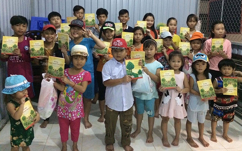 Asian children holding A Child's Garden of Bible Stories