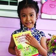 Thai Girl Holding A Child's Garden of Bible Stories
