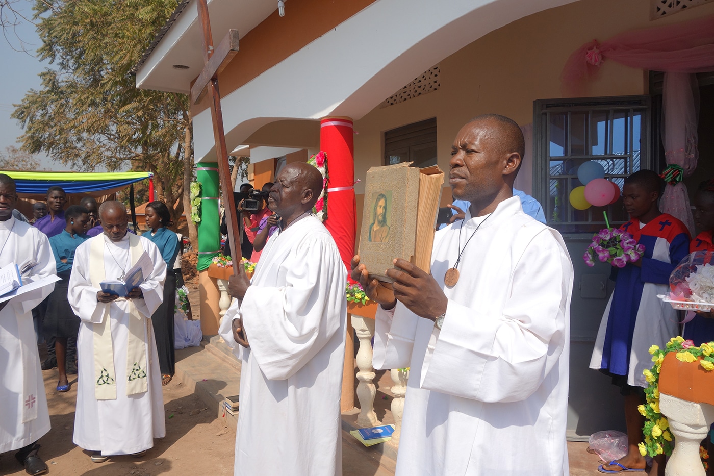 A procession of pastors holding the cross and a Bible